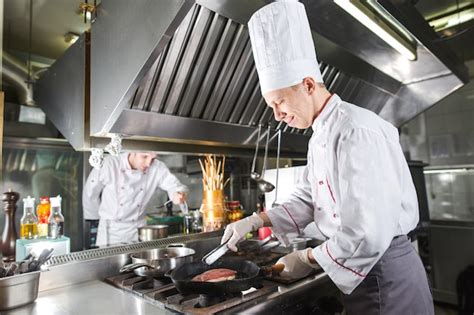 Chef En La Cocina Del Restaurante En La Estufa Con Pan Cocina Foto