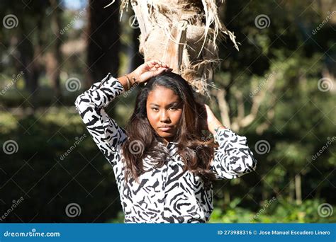 Bella Joven Latina Negra Vestida De Blanco Y Negro Inclinada En El Tronco De Una Palmera