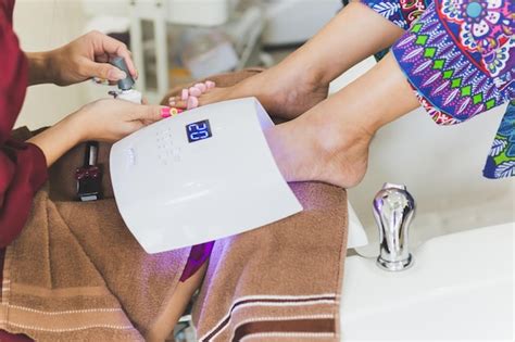 Premium Photo Womans Foot With A Pedicure Under Uv Lamp For Drying