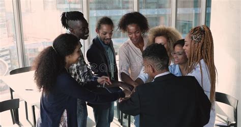 Employees Putting Hands In Air While Working In Open Office Stock