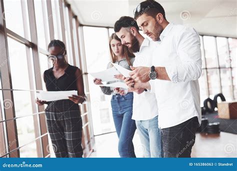 Personas Leyendo Documentos En La Oficina Con Grandes Ventanas Imagen
