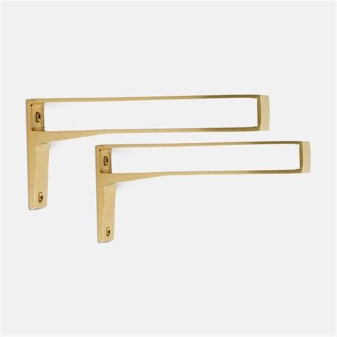 Two Gold Metal Brackets On A White Background