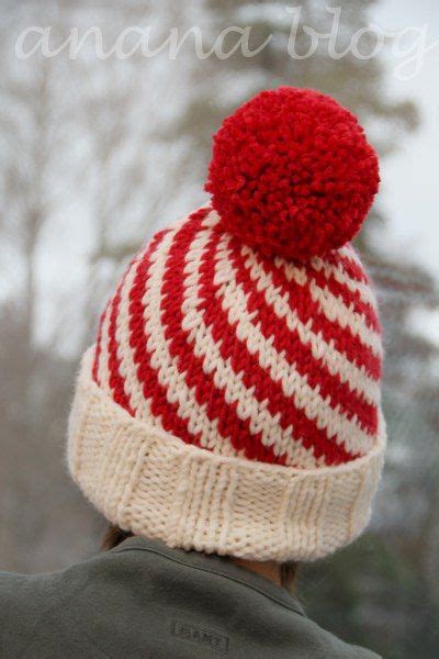 A Person Wearing A Red And White Striped Knitted Hat With A Pom Pom