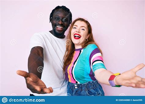 Interracial Couple Wearing Casual Clothes Smiling Cheerful Offering