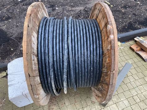 Large Spool With Black Thick Electrical Wire Or Cable Wooden Coil With