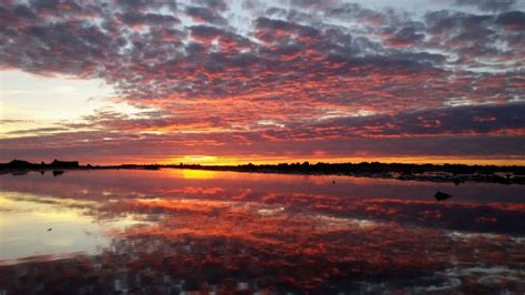 The Sky Is Reflected In The Water At Sunset