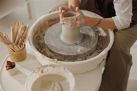 Close Up Of Artisan X S Hands Shaping Clay Bowl In Pottery Studio