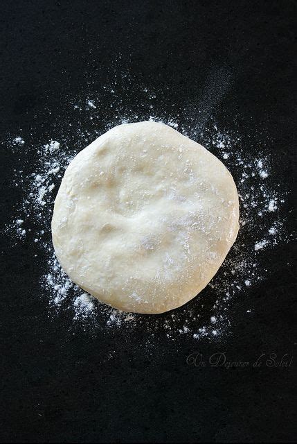 An Uncooked Pizza Dough Sitting On Top Of A Black Surface With Powdered