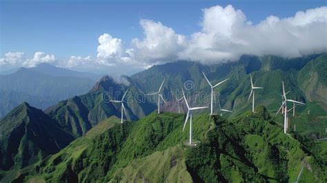 Wind Turbines Atop A Lush Green Mountain Under A Clear Blue Sky Dotted