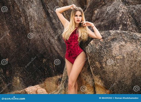 Belle Jeune Femme Blonde Dans Le Bikini Rouge Posant Sur La Plage