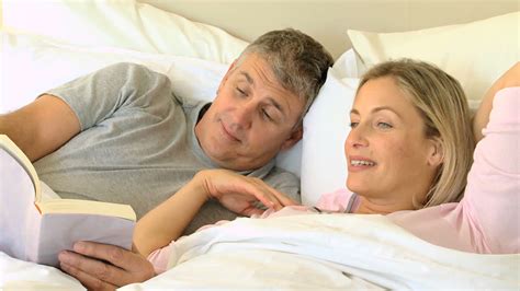 Premium Stock Video Couple Reading A Book In Bed