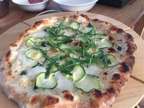 A White And Green Pizza With Truffle Cream Zucchini And Arugula