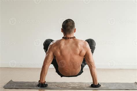 A Man With A Naked Torso Does Yoga Standing On His Hands Indoors Fitness Trainer 39908086 Stock