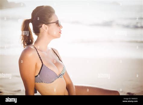 Glamouröse Frau im Bikini am Strand sitzen Stockfotografie Alamy