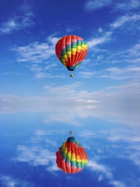 Premium Photo Hot Air Balloon Flying Over Sea Against Sky