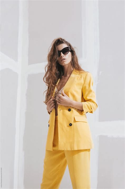 Young Female Fashion Model In Abstract White Space With Yellow Outfit