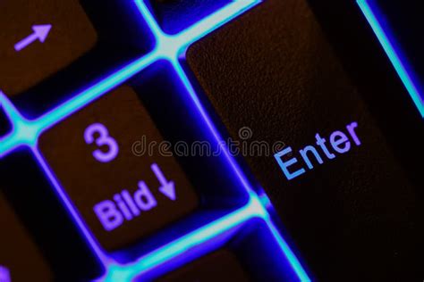 Macro Closeup Of Blue Illuminated Enter Key On Computer Keyboard Stock