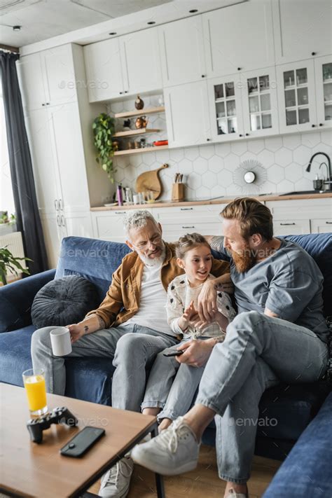 KYIV UKRAINE APRIL Smiling Preteen Girl Talking To Gay Parents With Remote