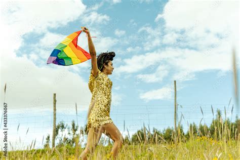 Mujer Transgenero Con Vestido Dorado Con Los Brazos Estirados Flameando