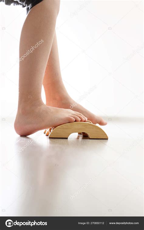 Feet Of Babys Naked Against The Background Of The Wooden Floor