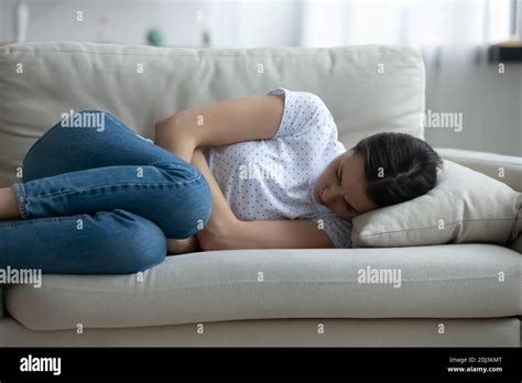 Close Up Unhappy Frustrated Young Woman Lying On Couch Alone Stock