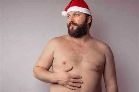 Free Photo Half Naked Bearded Man Wearing A Santa Claus Hat