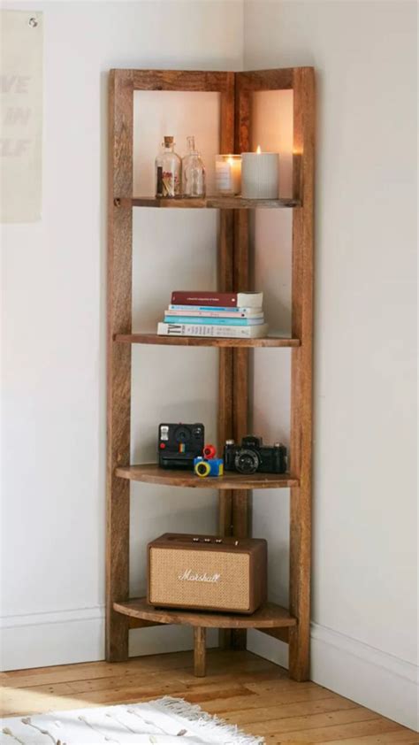 A Wooden Shelf With Books And Other Items On It In The Corner Of A Room