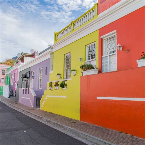 A Row Of Brightly Colored Houses On The Side Of A Street