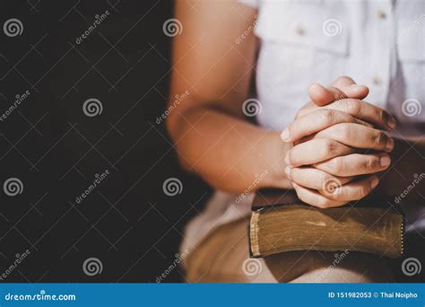 Hands Folded In Prayer On A Holy Bible In Church Concept For Faith