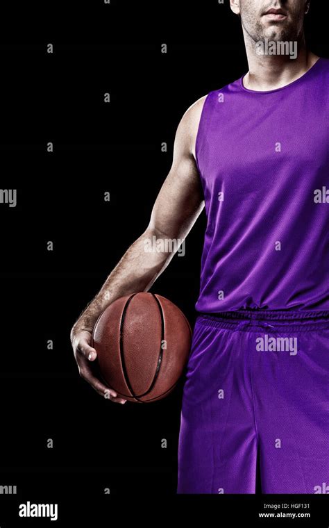 Basketball player on a purple uniform, on a black background Stock ...