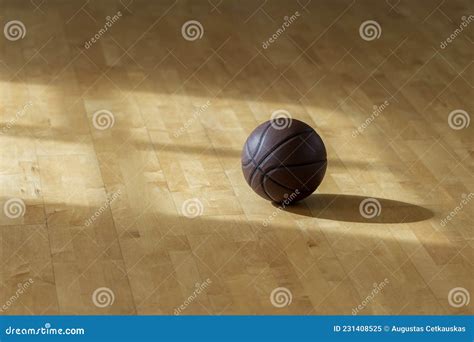 Basketball On Hardwood Court Floor With Natural Lighting Horizontal