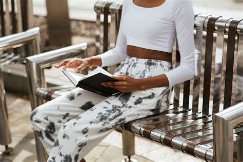 Mujer Afroamericana Sentada En Un Banco Y Leyendo Un Libro Foto Gratis