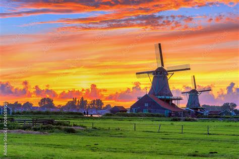 Traditional Village At Sunset With Dutch Windmills Bridge And River