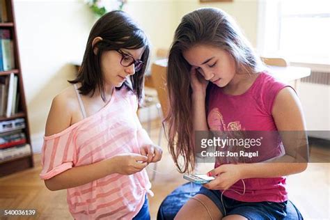 Two Preteen Girls Sharing Earphones Photos And Premium High Res