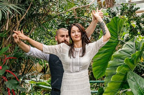 Premium Photo Beautiful Couple Girl And Guy In The Park Among Tropical Trees