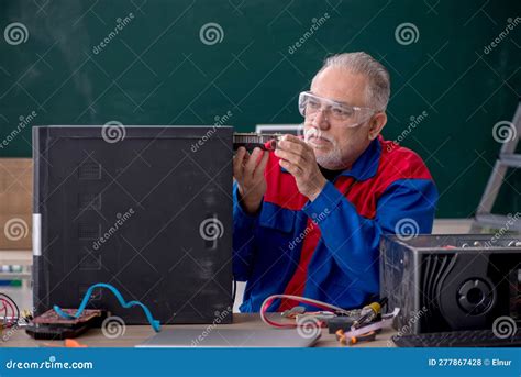 Old Repairman Repairing Computers In The Classroom Stock Photo Image