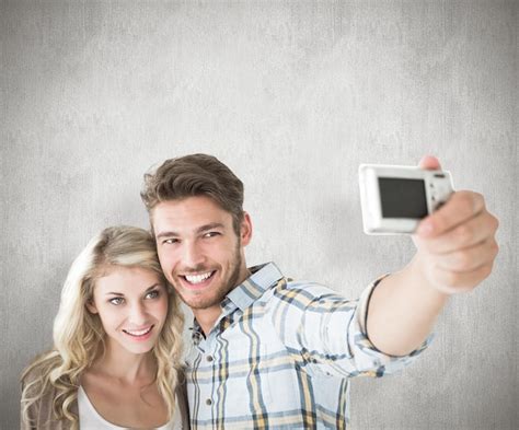 Atractiva Pareja Tomando Un Selfie Juntos Contra El Fondo Blanco