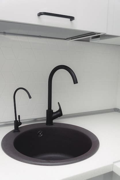 Premium Photo | Black kitchen sink with white minimalist backsplash ...