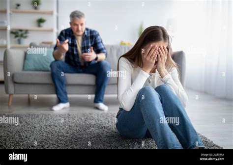 Emotional abuse in marriages concept. Mature woman crying on floor, her ...