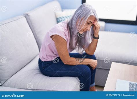 Middle Age Grey Haired Woman Stressed Sitting On Sofa At Home Stock