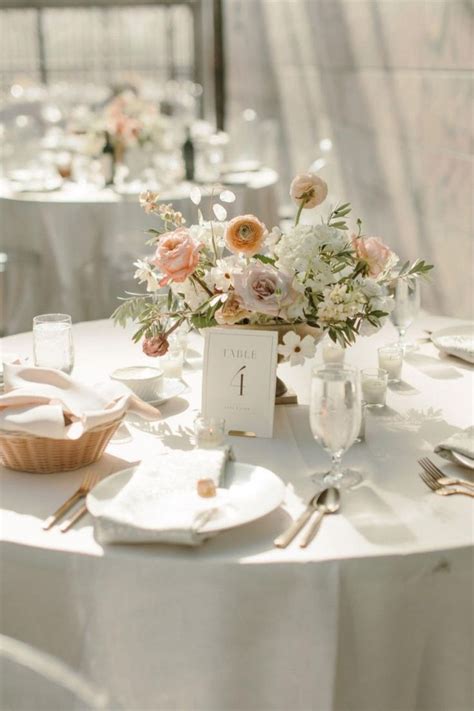 The Table Is Set With White Linens And Silverware Flowers In Vases