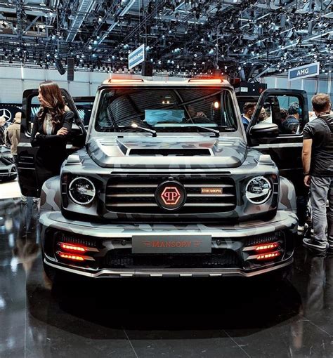 People Looking At Vehicles On Display In A Showroom