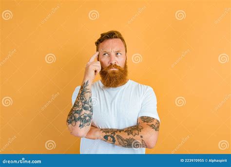 Hombre Atento Con Tatuaje De Barba Y Camiseta Blanca Imagen De Archivo