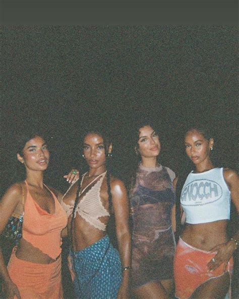 Four Women Standing Next To Each Other In Bathing Suits