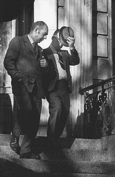 Black And White Photograph Of Two Men In Suits Walking Up Steps With