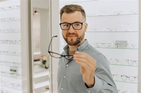 Joven Eligiendo Gafas En La Tienda De Ptica Foto Premium