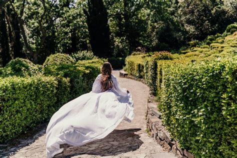 Brunette Runs White Dress Park A Beautiful Woman With Long Brown Hair And A Long White Dress