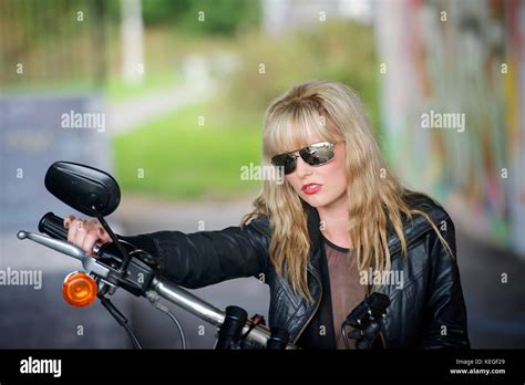 Beautiful Blonde Girl In Black With A Harley Davidson Motorcycle Stock Photo Alamy