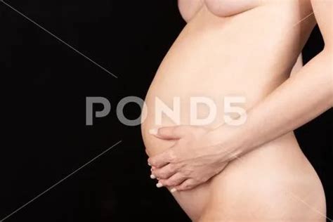 Naked Pregnant Woman In Profile On A Black Background Stock Photo