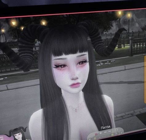 A Woman With Long Black Hair And Horns On Her Head In Front Of A Tv Screen